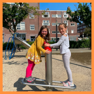 Due bambine giocano al parco durante il camp meivakantie e sorridono