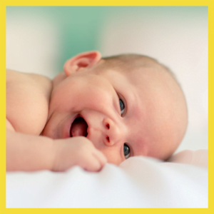 Een pasgeboren baby die op een laken ligt, glimlacht en herinnert zich het belang van de kinder-EHBO-workshop 2023