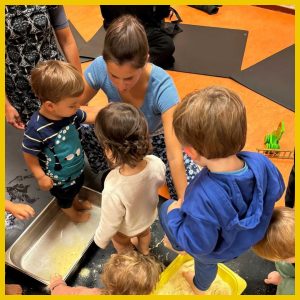 bambini di 3-4 anni fanno travasi insieme a un'educatrice