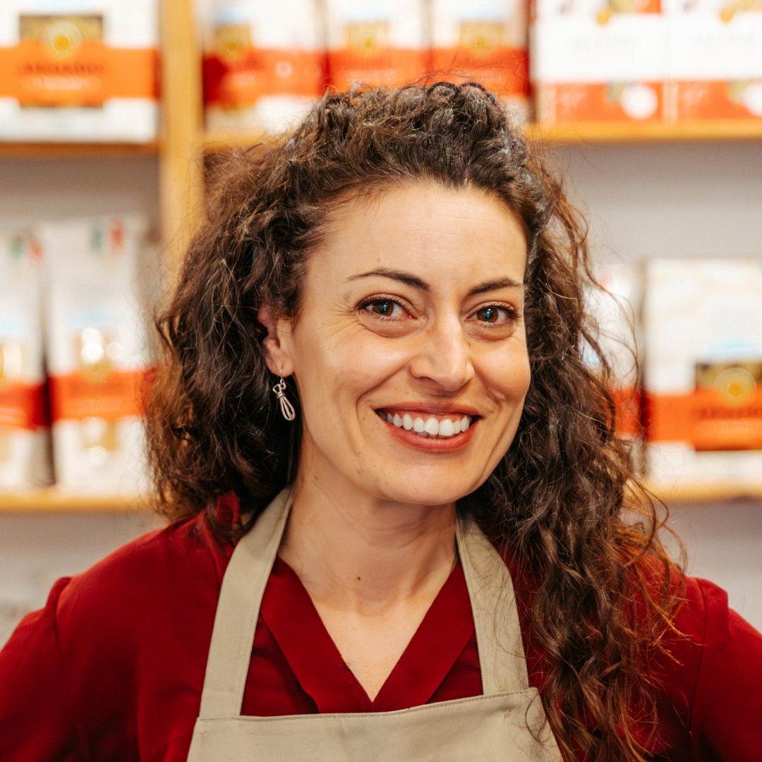 Close up of Alexandra smiling with long dark curly hair